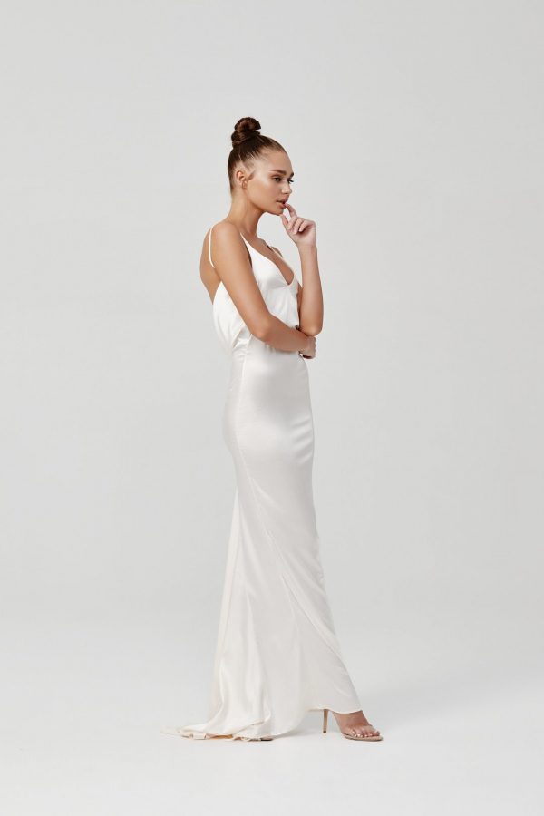 Model wearing Lexi Gabrielle cream bias-cut satin slip gown with subtle train