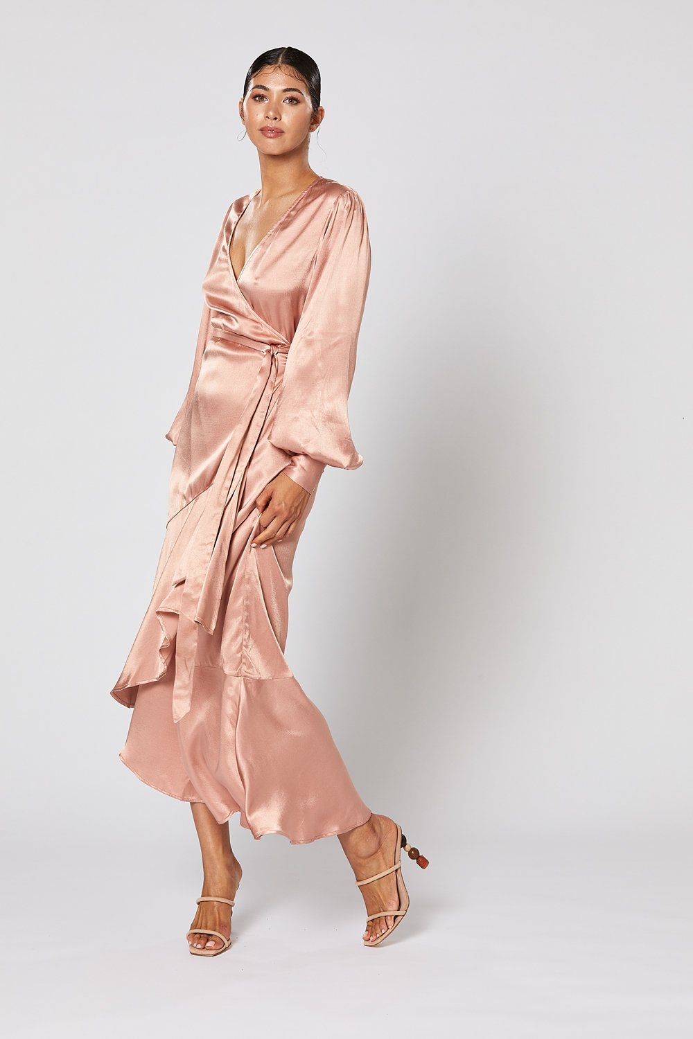Model wearing Winona Miele dusty pink satin wrap dress with bias ruffle hem demonstrating the side of the dress