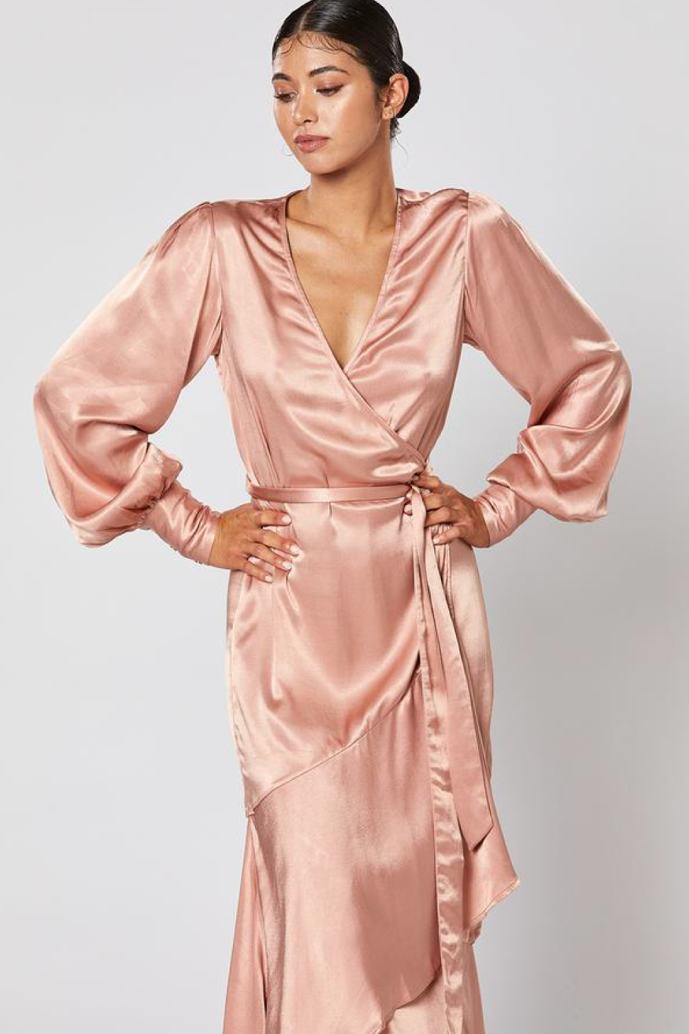 Model wearing Winona Miele dusty pink satin wrap dress with bias ruffle hem