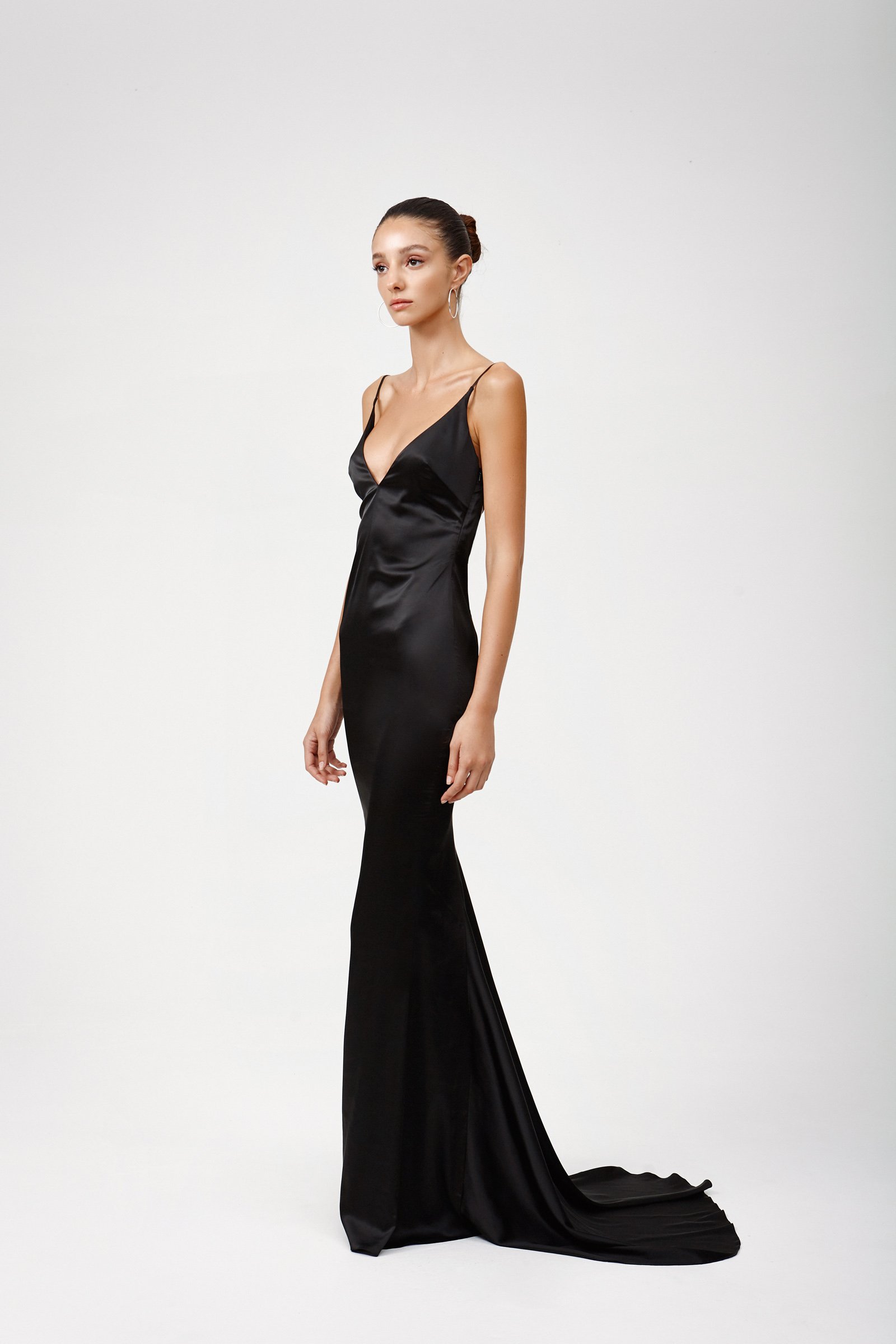 Model wearing Lexi Esmae black bias-cut satin gown with puddle train