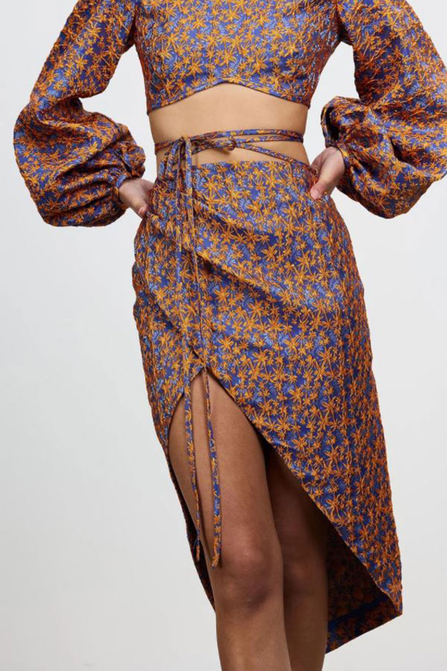 Close-up of orange and cobalt floral embroidery on Nicola Finetti set