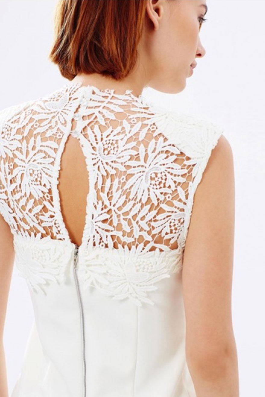 Close-up of floral lace hem panel on White Suede white crepe dress